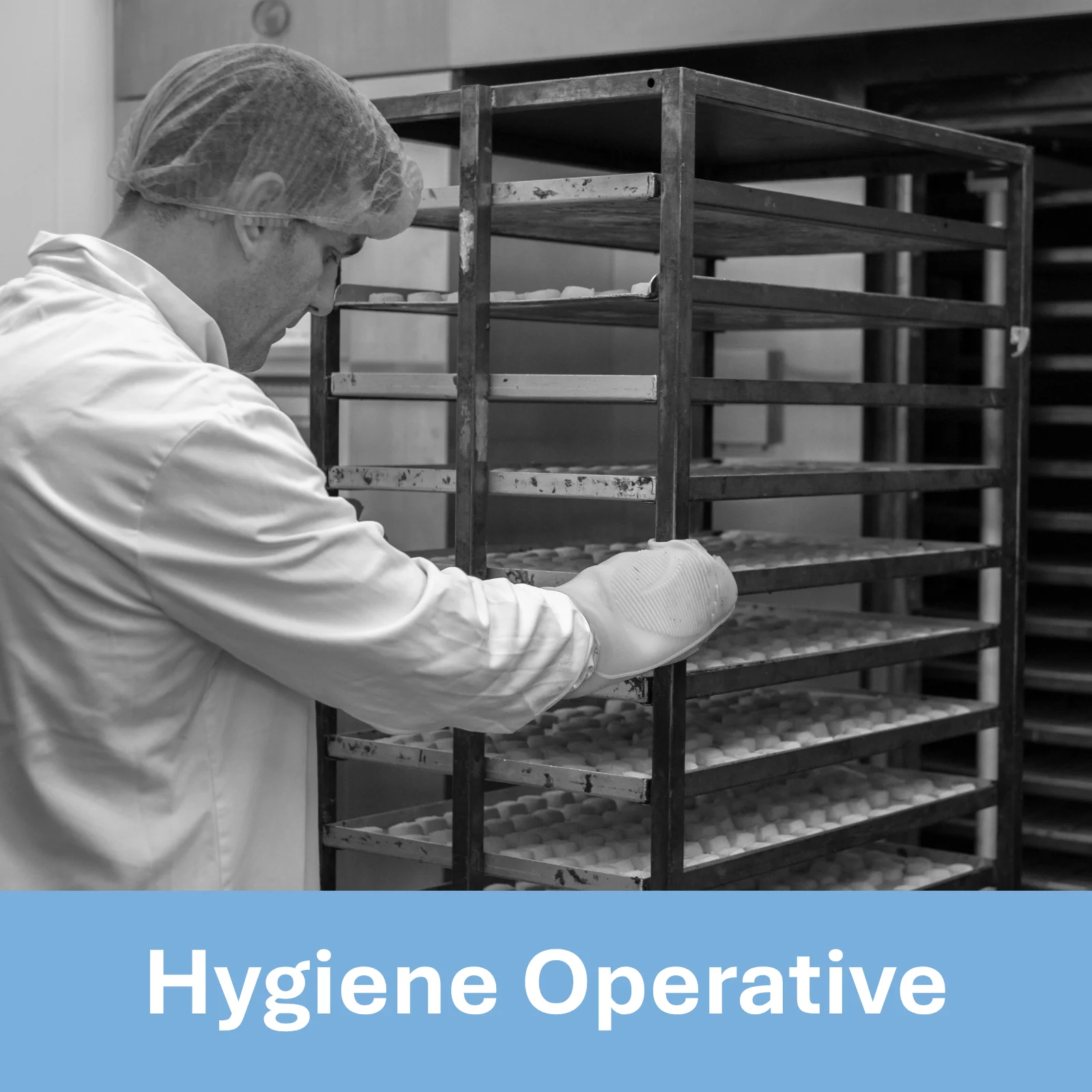 Black and white photo of a man in hairnet and bakery uniform wearing oven gloves, holding onto a large rack of baked goods. Text underneath reads Hygiene Operative